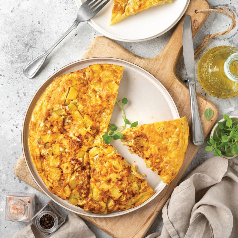 Frittata or potato pie in a ceramic plate on a light culinary background. Traditional Italian delicious homemade egg dish on the kitchen table. Top view